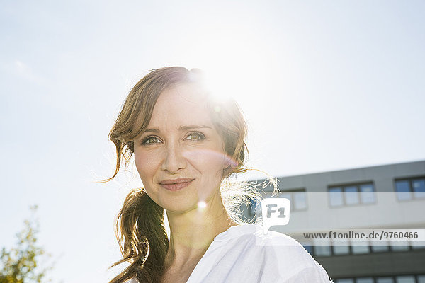 Portrait of smiling businesswoman at backlight