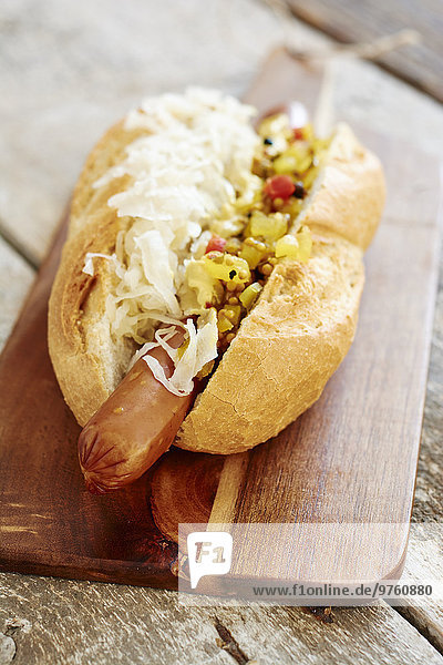 Veganer Hot Dog mit Sauerkraut und Genuss am Schneidebrett