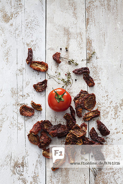 Getrocknete und frische Tomaten auf Holz