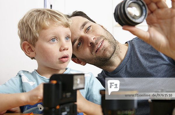 Father explaining analogue camera to son