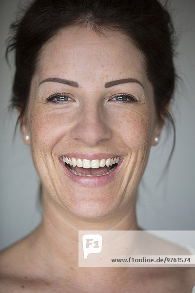 Porträt einer lachenden Frau mit Sommersprossen