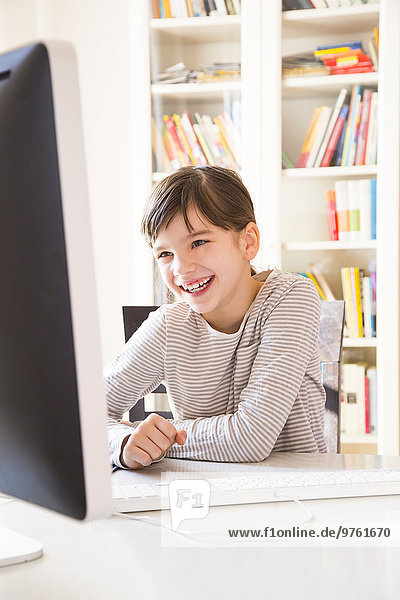 Portrait of smiling girl spending time at computer