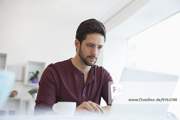 Portrait of man working with laptop at home office