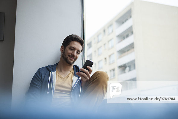 Smiling man reading SMS