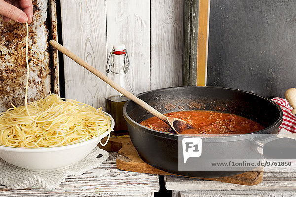 Spaghetti Bolognese  Spaghetti auf Teller und Sauce Bolognese in der Pfanne  Spaghetti knabbern