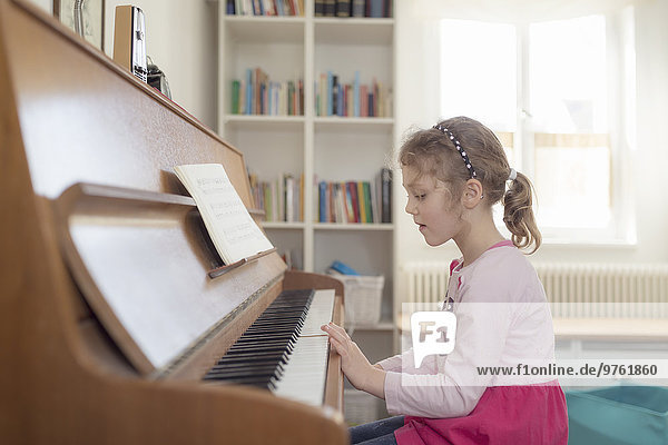 Kleines Mädchen spielt zu Hause Klavier