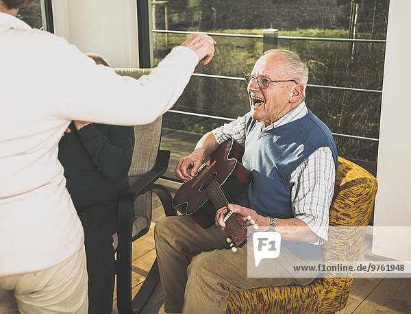 Älterer Mann spielt Gitarre für ältere Paare  die tanzen.