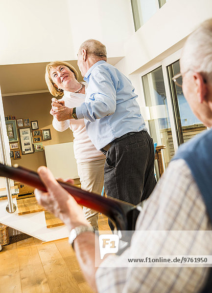 Älterer Mann spielt Gitarre für ältere Paare  die tanzen.