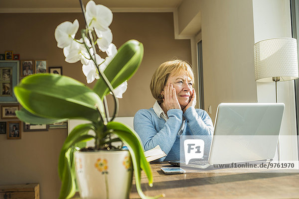 Seniorin zu Hause mit Laptop-Denken