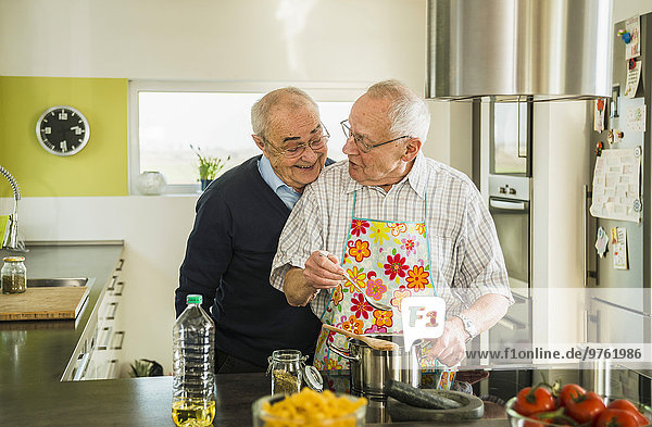 Zwei ältere Freunde beim Kochen in der Küche