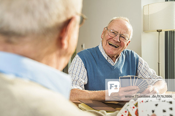 Zwei ältere Freunde beim Kartenspielen