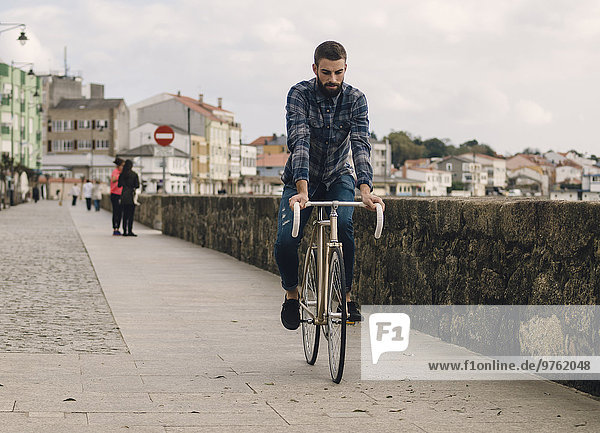 Spain  Galicia  Ares  hipster man riding with a fixie bike