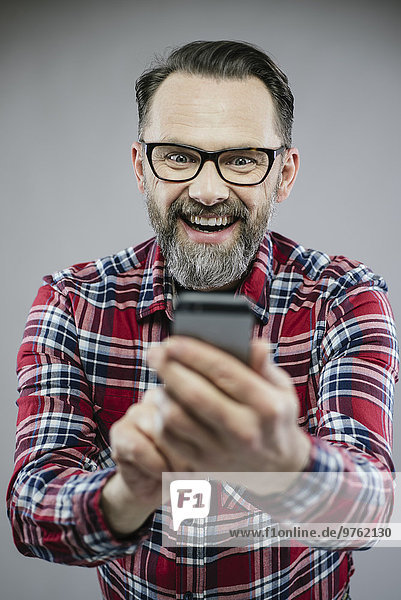 Porträt eines aufgeregten Mannes auf dem Smartphone