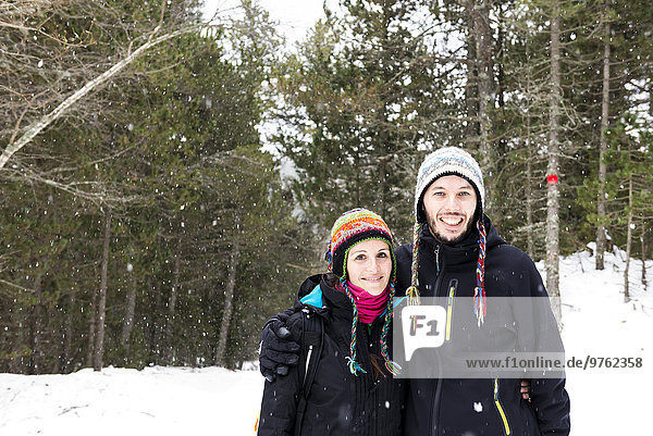 Smiling couple in forest in winter