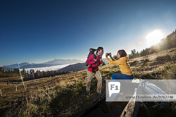 Austria  Altenmarkt-Zauchensee  young couple taking picture on hiking trip at Niedere Tauern