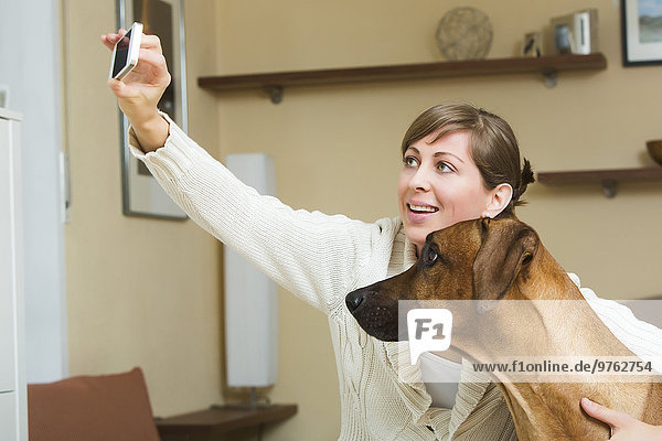 Woman taking selfie with her Rhodesian Ridgeback dog