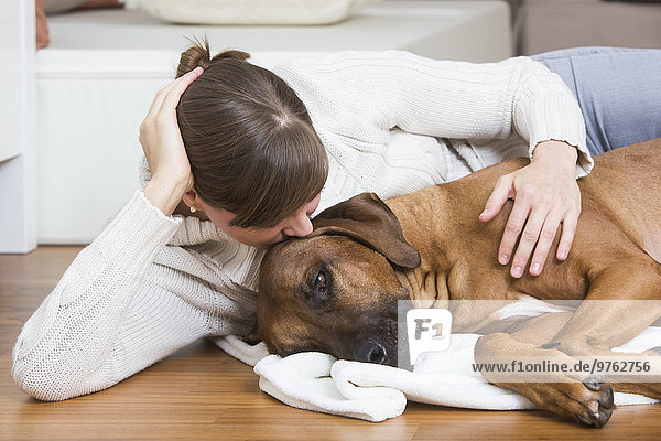 Woman caressing her Rhodesian Ridgeback dog