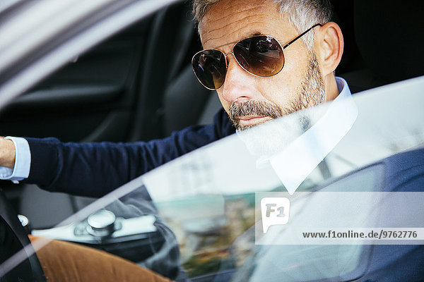 Man with sunglasses driving car