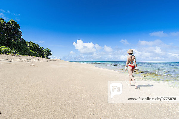Woman walking on a white sand beach on a little islet in Haapai  Haapai Islands  Tonga  South Pacific  Pacific