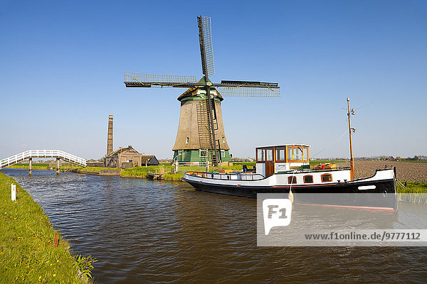 Traditional Windmill beside a Canal  near Obdam  North Holland  Netherlands  Europe