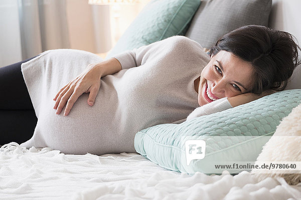 Frau lächeln Bett Schwangerschaft