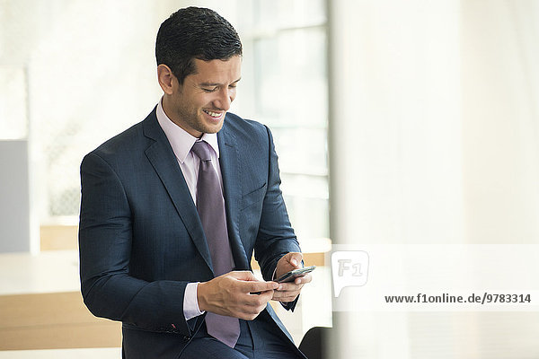 Businessman looking at smartphone and smiling