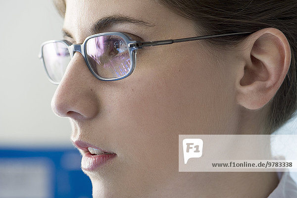 Junge Frau mit Brille  die in Gedanken wegschaut  Profil