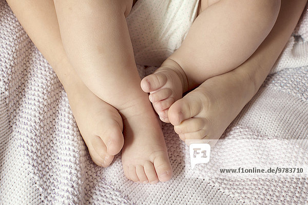 Close-up of child and baby's bare feet