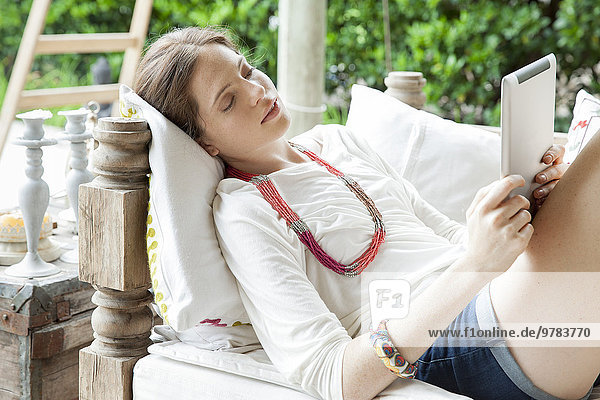 Young woman relaxing with digital tablet