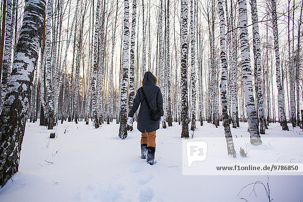 Caucasian woman walking in snowy forest