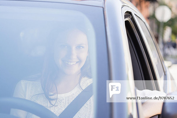 Caucasian woman smiling in car