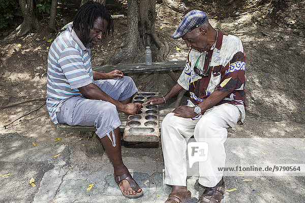 Zwei einheimische Männer beim Brettspiel Warri  Nelson's Dockyard  English Harbour  Antigua  Antigua und Barbuda  Nordamerika