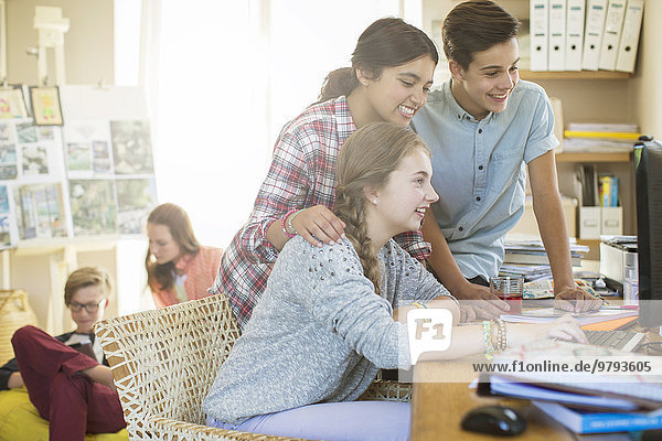 Teenager teilen sich den Computer im Wohnzimmer