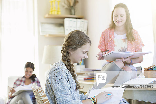 Drei Teenager-Mädchen bei den Hausaufgaben im Zimmer