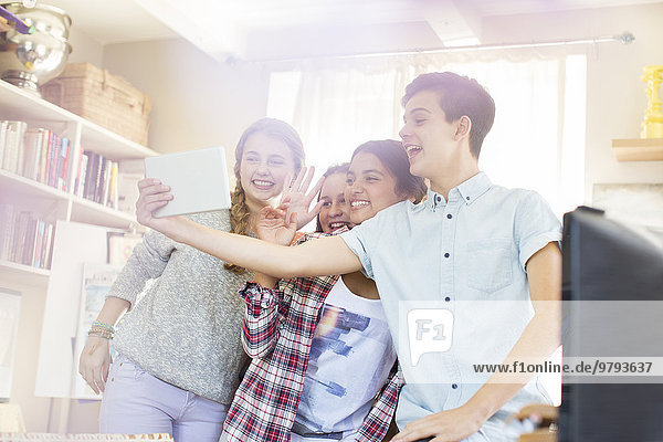 Teenager nehmen Selfie mit digitalem Tablett auf dem Zimmer
