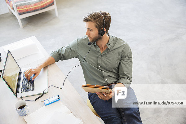 Young man sitting at desk working with laptop