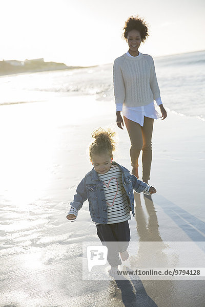 Mutter und Tochter beim Spaziergang am Strand
