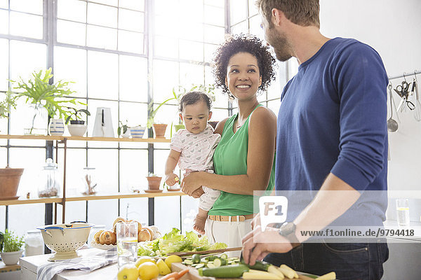Happy family preparing meal in domestic kitchen