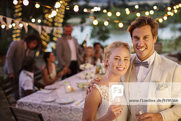 Portrait of young couple during wedding reception in domestic garden