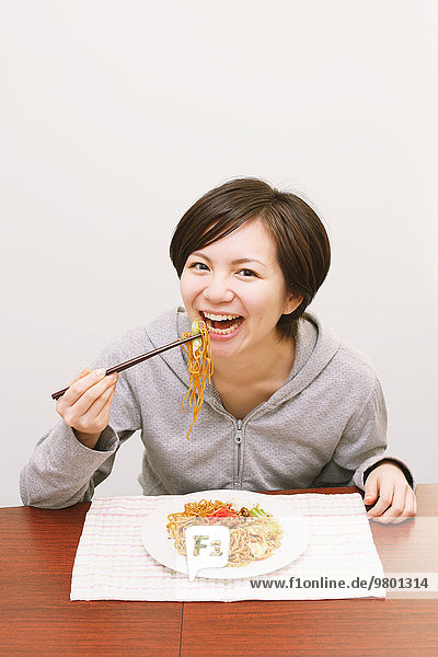 Frau jung essen essend isst Pasta Nudel japanisch