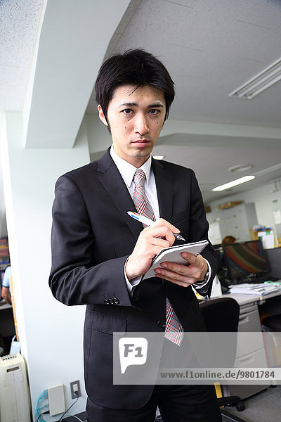 Young Japanese freshman working in the office