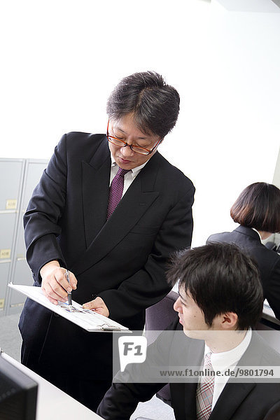Young Japanese businessman working with his boss