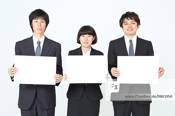 Young Japanese business people holding white boards