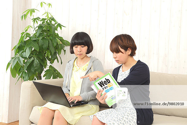 Young Japanese women working with laptop on the sofa