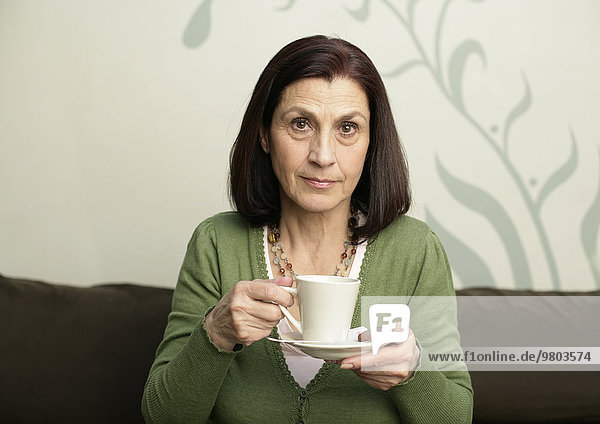 Ältere Frau trinkt eine Tasse Kaffee