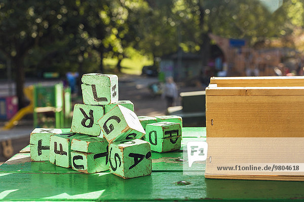 Grüne Holzklötze auf dem Tisch vor dem Kindergarten