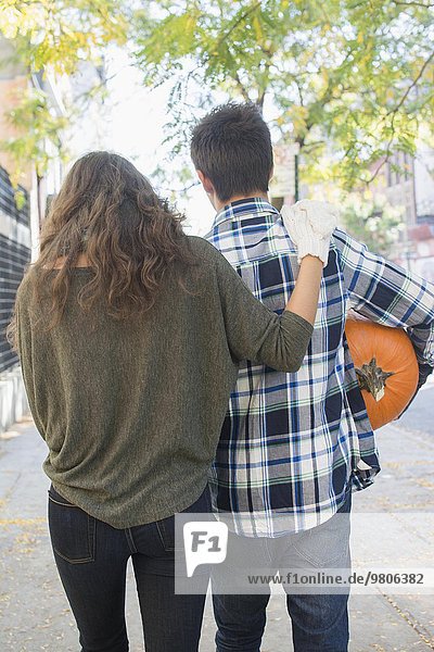 Rear view of young couple on sidewalk