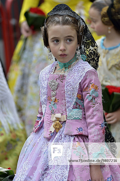 Fallas festival  girl in a traditional costume during the parade in the Plaza de la Virgen de los Desamparados  Valencia  Spain  Europe