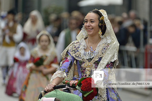 Fallas-Fest  junge Frau in Tracht bei Blumengabe  traditioneller Umzug an der Plaza de la Virgen de los Desamparados  Valencia  Spanien  Europa