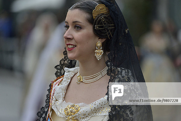 Fallas festival  woman in a traditional costume during the parade in the Plaza de la Virgen de los Desamparados  Valencia  Spain  Europe